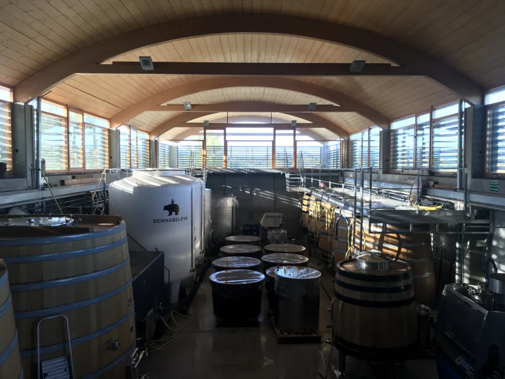 Bodega moderna equipada con tanques de acero inoxidable y barricas de roble para fermentación de vino blanco