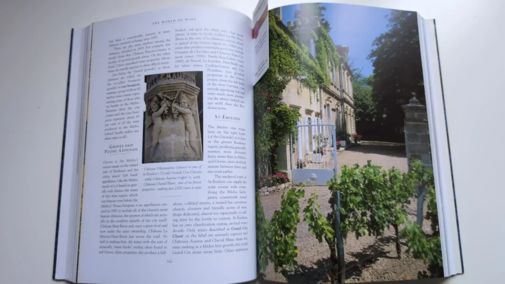 Páginas de un libro de vino dedicadas a la región de Burdeos, con un enfoque en St-Émilion y una fotografía de un clásico château francés.