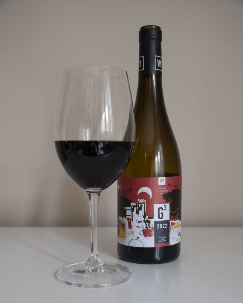 Botella del vino tinto G3 2022 de Bodegas Valleyglesias junto a una copa de vino servida, sobre un fondo neutro.