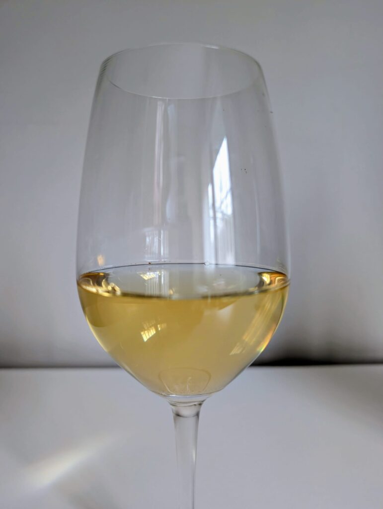 Copa de vino Albillo Real mostrando color amarillo pálido característico de esta variedad blanca