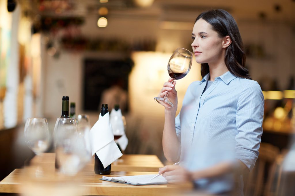 Persona analizando los aromas de un vino tinto durante una cata.